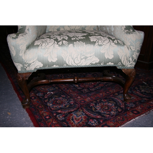 767 - An 18th century style upholstered wing back armchair on shell capped dwarf cabriole legs, with pad f... 