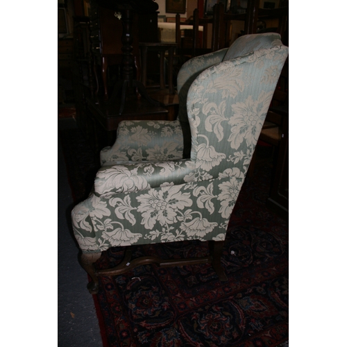 767 - An 18th century style upholstered wing back armchair on shell capped dwarf cabriole legs, with pad f... 