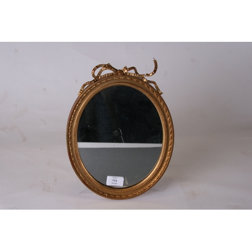 773 - A pair of George III style oval gilt gesso ribbon tie wall mirrors, 23cms (9ins) diameter.