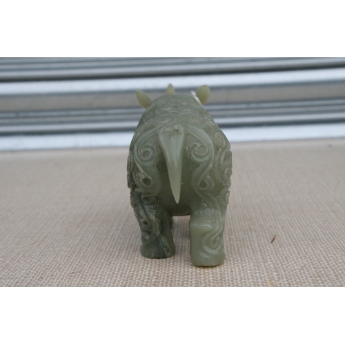 494 - A Chinese jade / hardstone carving in the form of a rhinoceros, 18cms (7ins) long.