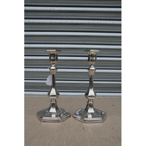 160 - A pair of Edwardian silver candlesticks, each with slender baluster form columns on stepped hexagon ... 