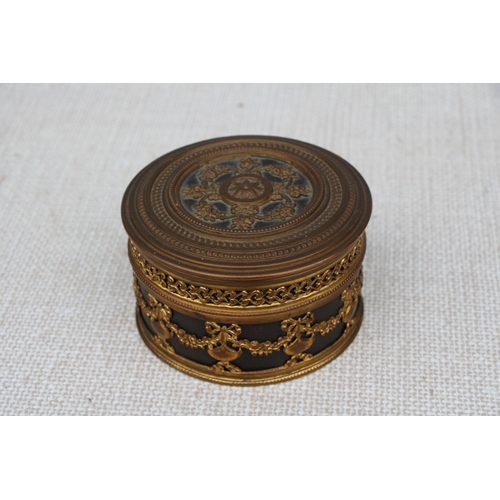 595 - A French gilt metal dressing table box, 11cms (4.75ins) diameter.