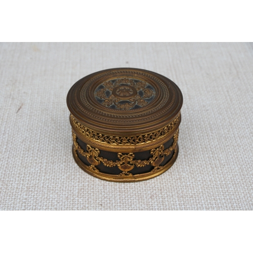 595 - A French gilt metal dressing table box, 11cms (4.75ins) diameter.