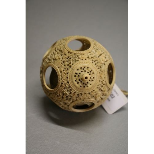 502 - A 19th century Chinese ivory hanging puzzle ball decorated with figures in a landscape, 10cms 94ins)... 