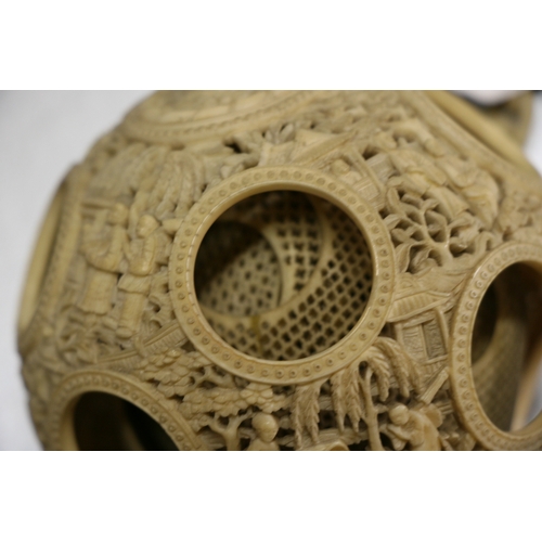 502 - A 19th century Chinese ivory hanging puzzle ball decorated with figures in a landscape, 10cms 94ins)... 