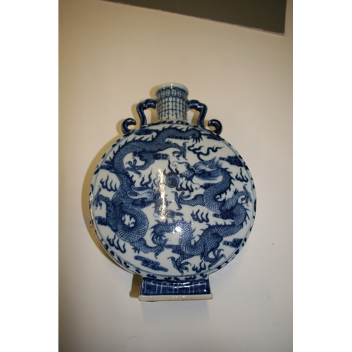 449 - A Chinese blue & white moon flask decorated dragons chasing a flaming pearl and foliate scrolls, fou... 