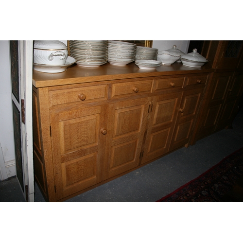 779 - A Monk Man Arts & Crafts style oak sideboard with four drawers above two pairs of panelled doors, on... 