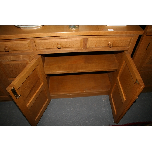 779 - A Monk Man Arts & Crafts style oak sideboard with four drawers above two pairs of panelled doors, on... 