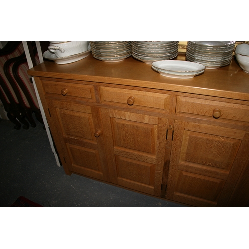 779 - A Monk Man Arts & Crafts style oak sideboard with four drawers above two pairs of panelled doors, on... 