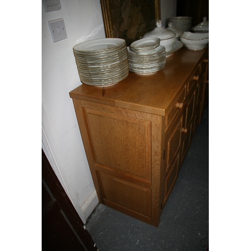 779 - A Monk Man Arts & Crafts style oak sideboard with four drawers above two pairs of panelled doors, on... 