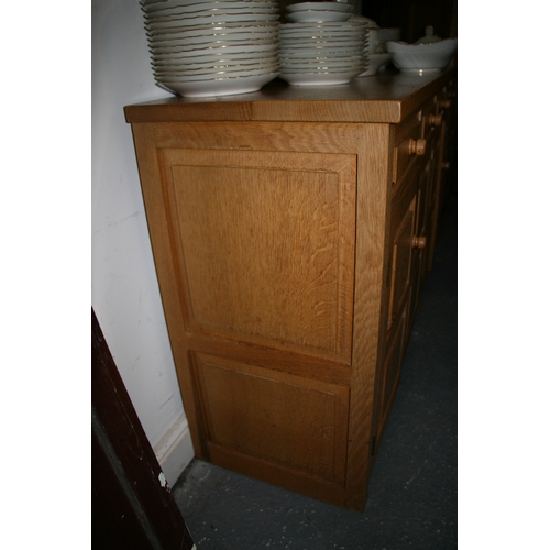 779 - A Monk Man Arts & Crafts style oak sideboard with four drawers above two pairs of panelled doors, on... 