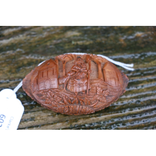 602 - A Georgian coquilla nut snuff box deeply carved with a figural scene depicting a woman holding a bab... 