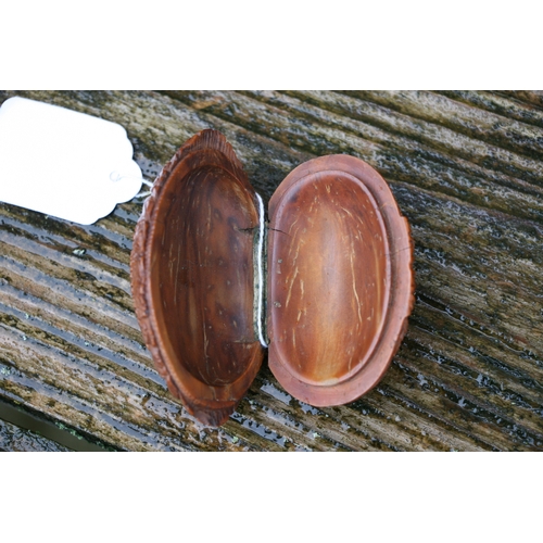 602 - A Georgian coquilla nut snuff box deeply carved with a figural scene depicting a woman holding a bab... 