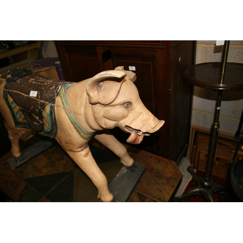 638 - A carved and painted wooden carousel figure in the form of a pig, 80cms (31.5ins) wide.