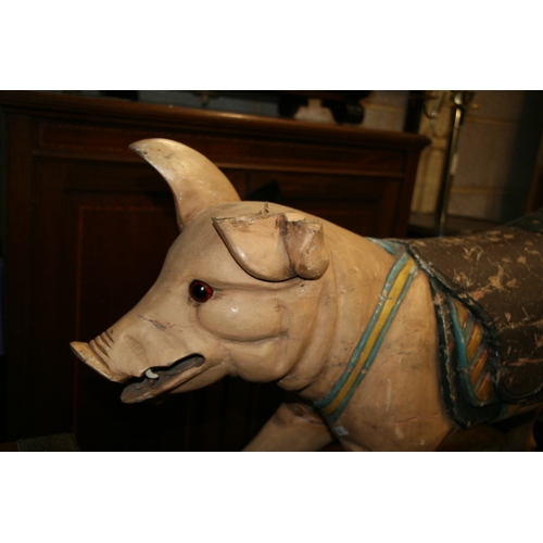 638 - A carved and painted wooden carousel figure in the form of a pig, 80cms (31.5ins) wide.