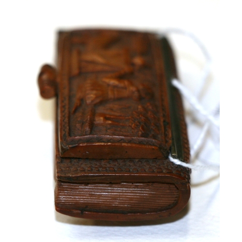 601 - A 19th century coquilla nut snuff box, finely carved with Cupid, 7.5cms (3ins) wide.