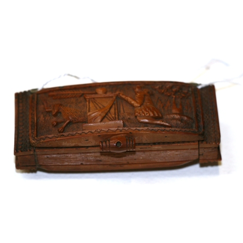 601 - A 19th century coquilla nut snuff box, finely carved with Cupid, 7.5cms (3ins) wide.