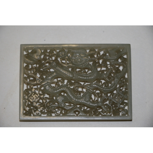 463 - A Chinese pierced rectangular jade plaque depicting a dragon, birds and bats amongst foliage, on a h... 