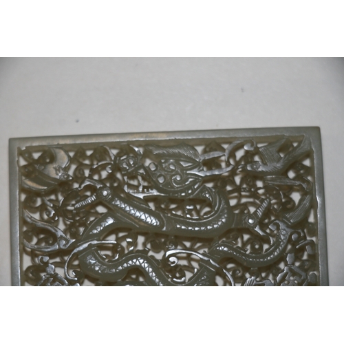 463 - A Chinese pierced rectangular jade plaque depicting a dragon, birds and bats amongst foliage, on a h... 