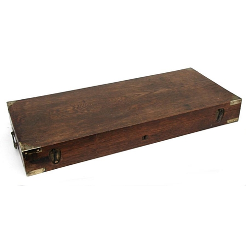 150 - An oak gun case with brass corners and carrying handles, 83cms (32.5ins) wide.