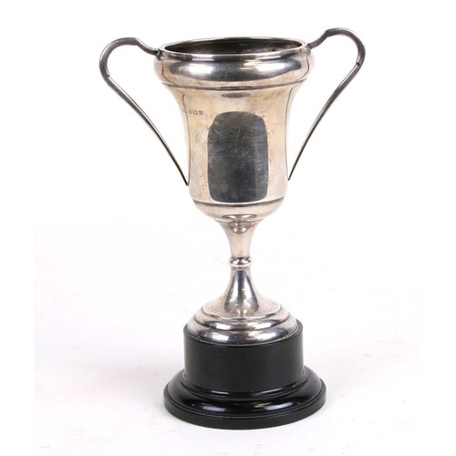 203 - A silver two-handled trophy cup on an ebonised plinth, Birmingham 1938, overall 20cms (8ins) high.