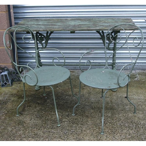 22 - A painted cast iron garden table with wooden slatted top, 138cms (54ins) wide; together with two mat... 