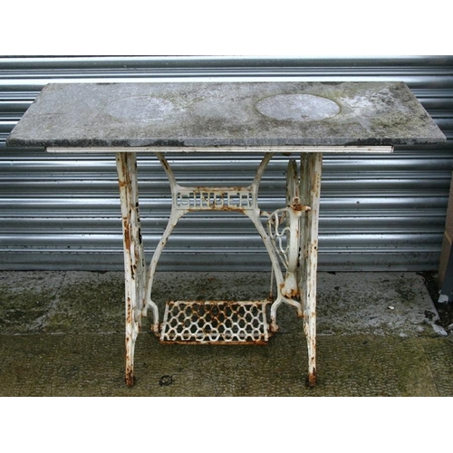 23 - A cast iron garden table with slate rectangular top, 107cms (42ins) wide.