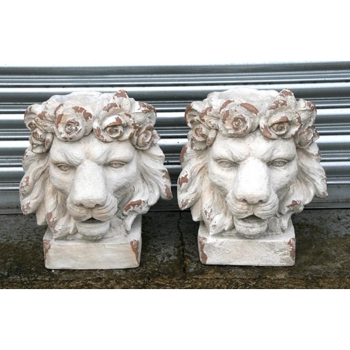 30 - A pair of distressed painted urns in the form of lion heads, each 43cms (17ins) high (2).