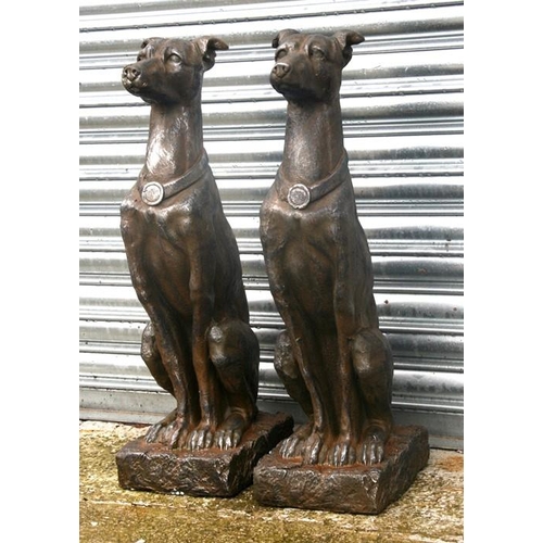 38 - A pair of faux stone (fibreglass) garden figures in the form of seated dogs, 79cms (31ins) high.