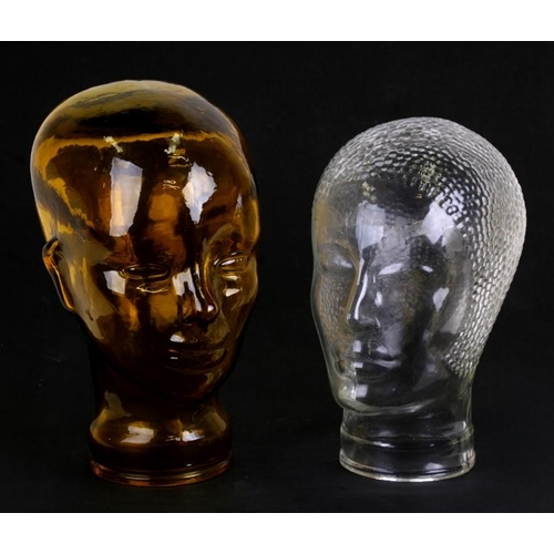 42 - An amber glass mannikin head; together with another similar in the Art Deco style, the largest 28cms... 