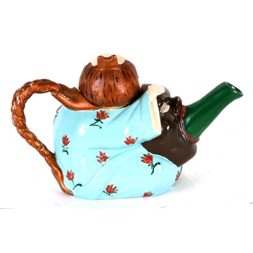 78 - A majolica 'Mandarin' teapot and cover in the form of a seated Chinaman holding a mask with spout em... 