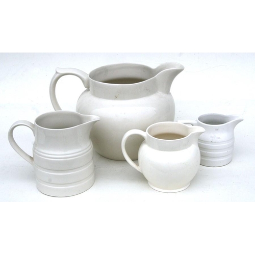 92 - A group of four cream glazed jugs, the largest 23cms (9ins) high.