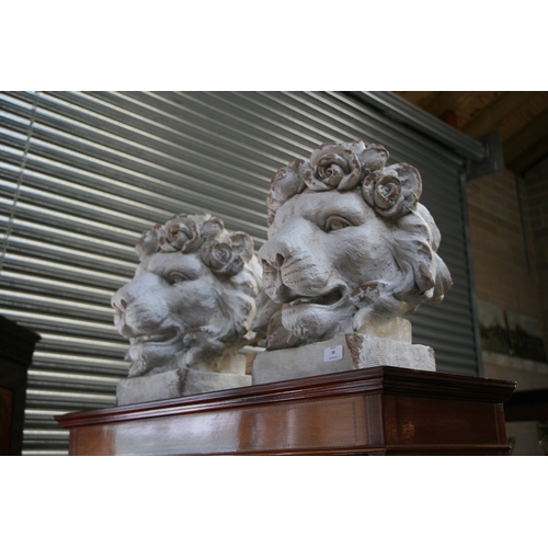 30 - A pair of distressed painted urns in the form of lion heads, each 43cms (17ins) high (2).