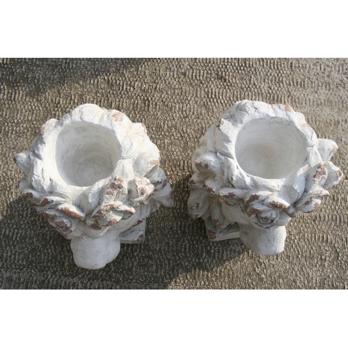 30 - A pair of distressed painted urns in the form of lion heads, each 43cms (17ins) high (2).