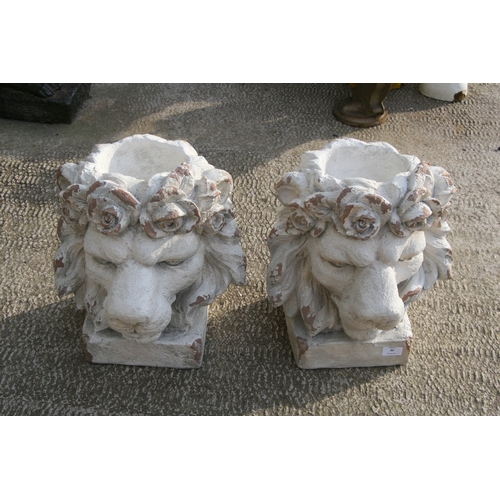 30 - A pair of distressed painted urns in the form of lion heads, each 43cms (17ins) high (2).