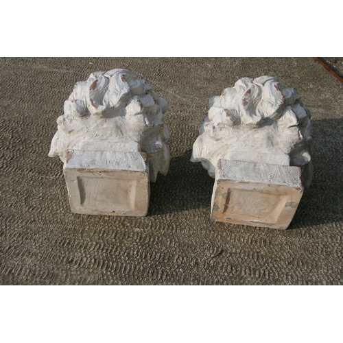 30 - A pair of distressed painted urns in the form of lion heads, each 43cms (17ins) high (2).