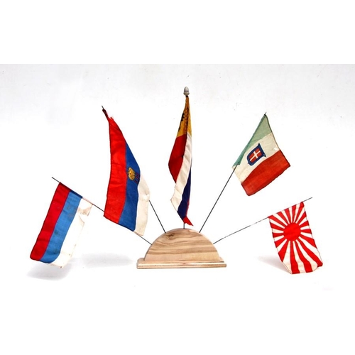 78 - Five 1930's miniature National Flags to include Japan, on a wooden stand.
