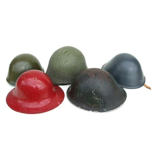 80 - A US Army helmet with camo net; together with four similar helmets (5).