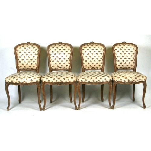 1004 - A set of eight French limed beech dining chairs with upholstered seats and backs, on cabriole front ... 