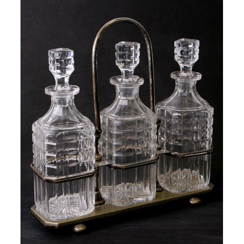 101 - A silver plated three-bottle decanter stand with three cut glass decanters, 30cms high.