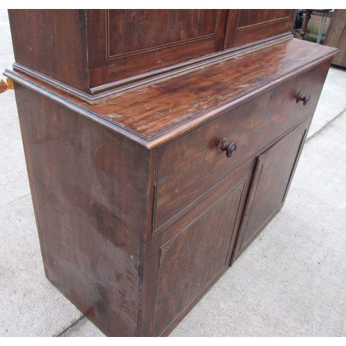 1021 - A 19th century mahogany secretaire cupboard, the dentil cornice above two panelled doors, the lower ... 