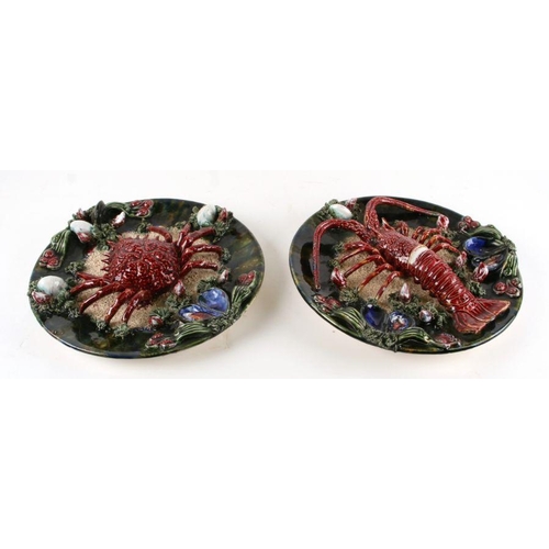 145 - A pair of Palissy style plates, applied with a lobster and a spider crab, each 30cms diameter (2).