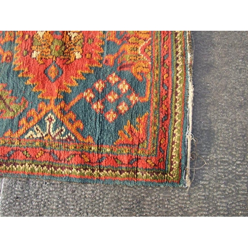 235 - A Turkish hand knotted woollen runner with repeated floral motifs on a blue ground within a multi bo... 