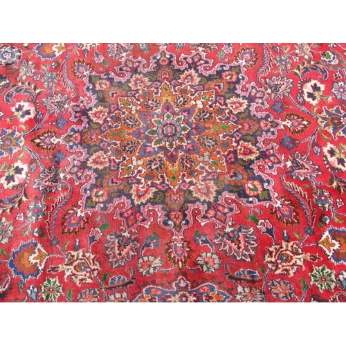 240 - A Persian Mashad woollen hand knotted carpet with central foliate gul within foliate borders, on a r... 