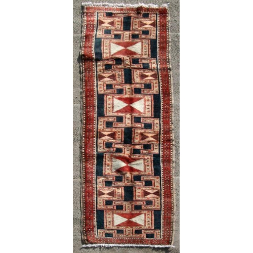 247 - A Persian Tabriz hand knotted woollen runner with geometric design on a red ground, 295 by 75cms (41... 