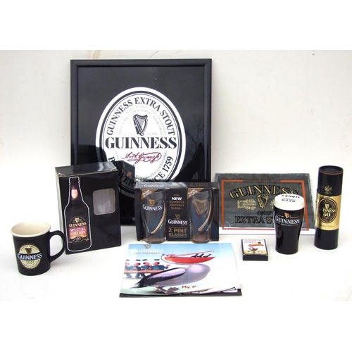 527 - A quantity of Guinness related collectables to include glasses, money box and mirror.