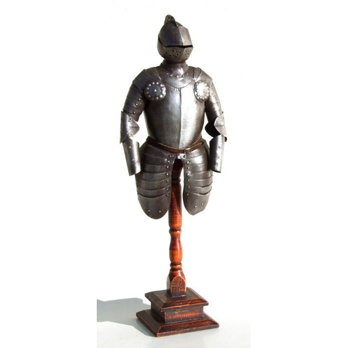 61 - A tin plate miniature suit of armour mounted on a wooden stand 55cms (21.625ins) high