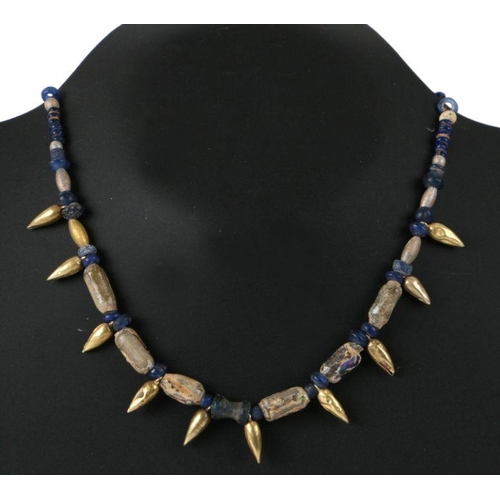 674 - A possibly Parthian (247BC to 224AD) yellow coloured metal and blue graduated bead necklace.