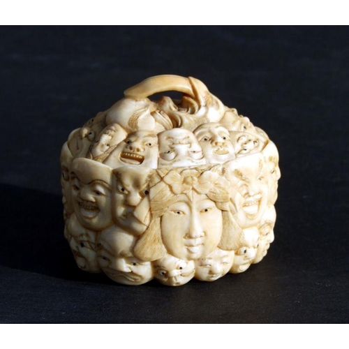 754 - A Chinese carved ivory box and cover, the surface profusely carved with images of faces, 5cms wide.