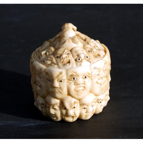 754 - A Chinese carved ivory box and cover, the surface profusely carved with images of faces, 5cms wide.